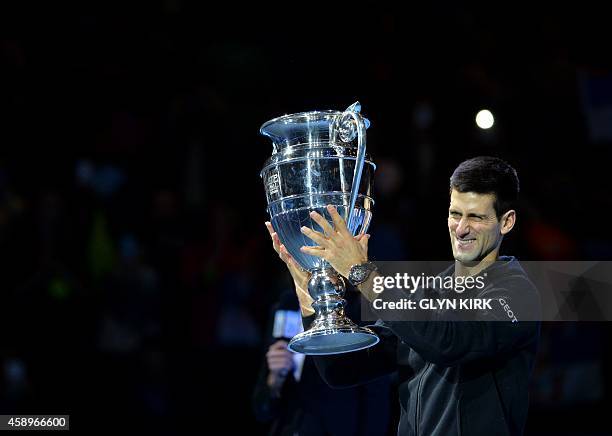 Serbia's Novak Djokovic kisses the trophy of the ATP World No 1 Award after it was presented to him following his Group A singles match win against...