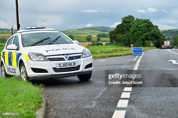 british police car parked at the side of the road - police scotland stock pictures, royalty-free photos & images