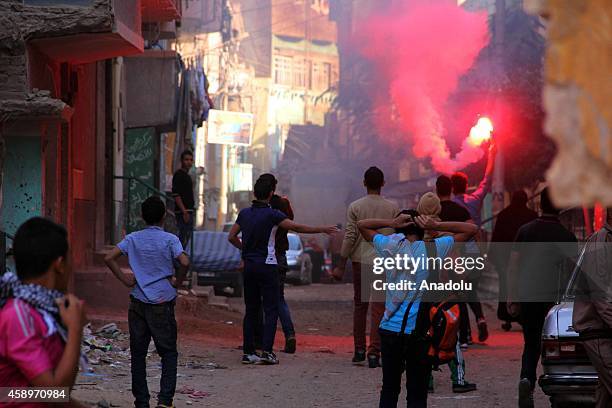 Egyptian protesters, who call themselves coup opponents, light flares during a protest in Badrasheen neighborhood of Giza, Egypt on November 14, 2014.