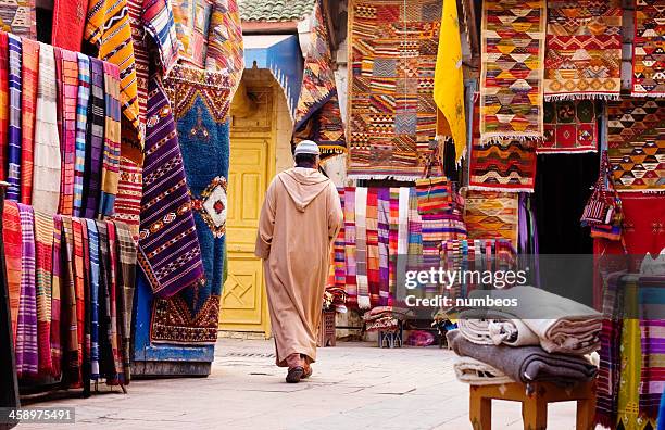 moroccan homme en passant par les tapis sellers, maroc - essaouira photos et images de collection
