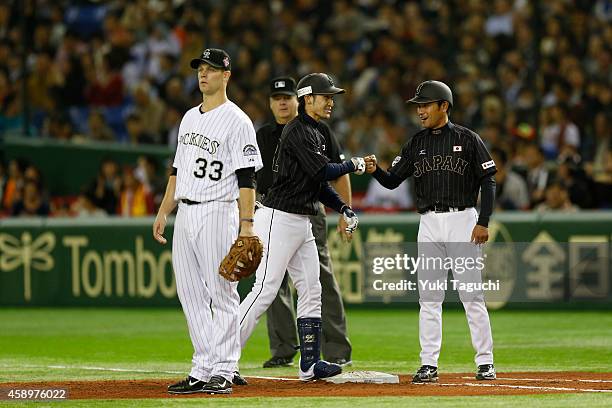 Hikaru Ito of Samurai Japan is greeted by first base coach after hitting an RBI single in the second inning during the game against the MLB All-Stars...