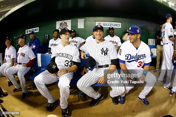 Justin Morneau of the Colorado Rockies, Chris Capuano of the New York Yankees and Drew Butera of the Los Angeles Dodgers get ready in the dugout...