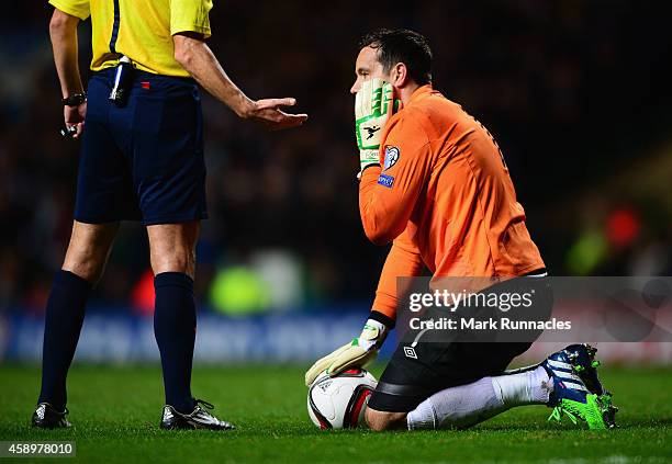 Goalkeeper David Forde of the Republic of Ireland holds his face as referee Milorad Mazic looks on during the EURO 2016 Group D Qualifier match...