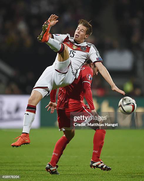 Erik Durm of Germany jumps for a header with Lee Casciaro of Gibraltar during the EURO 2016 Group D Qualifier match between Germany and Gibraltar at...