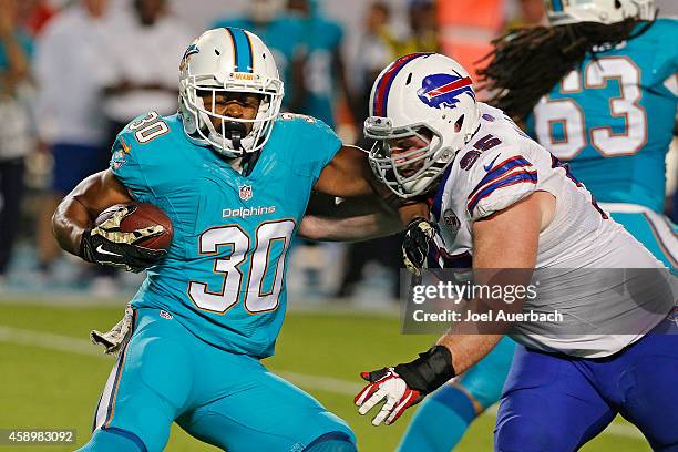 Stefan Charles of the Buffalo Bills tackles Daniel Thomas of the Miami Dolphins as he runs with the ball on November 13, 2014 at Sun Life Stadium in...