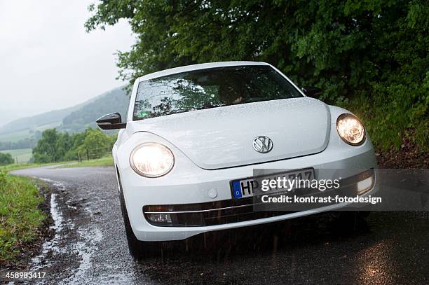 volkswagen new beetle on a countryroad - new beetle stock pictures, royalty-free photos & images