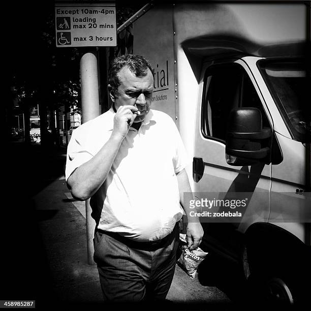 businessman smoking a cigarette in london - candid black and white corporate stock pictures, royalty-free photos & images