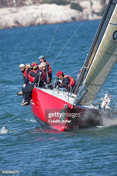 boat crew balancing their sailboat while tacking - sailing tacking stockfoto's en -beelden