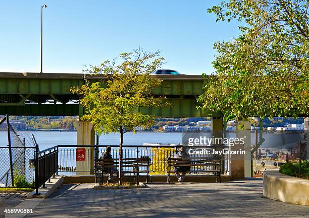 new york city life, people sitting near hudson river, manhattan - riverside park manhattan stock pictures, royalty-free photos & images