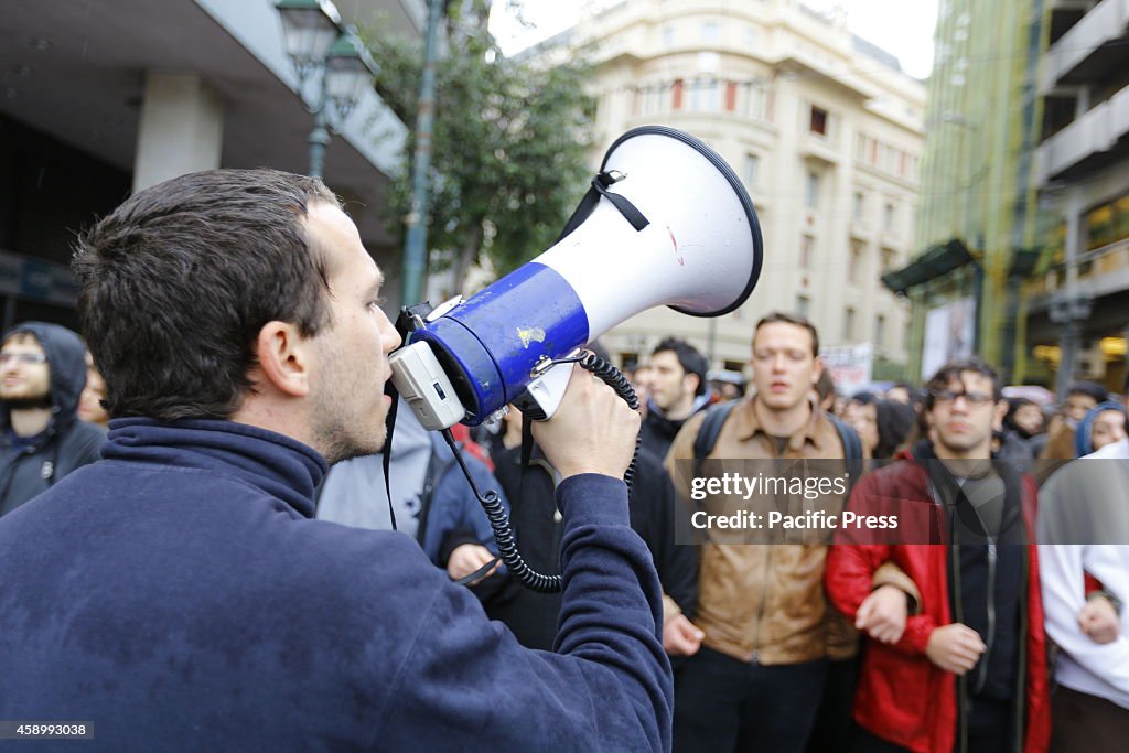 A student shouts slogans through a megaphone to the...