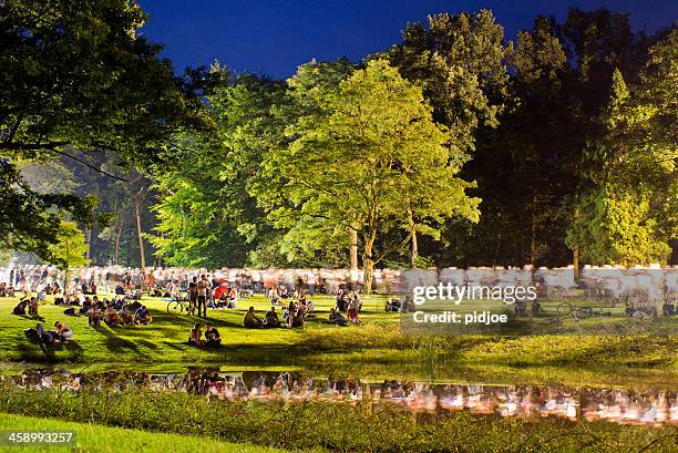 people walking through park after concert at night - nijmegen stockfoto's en -beelden