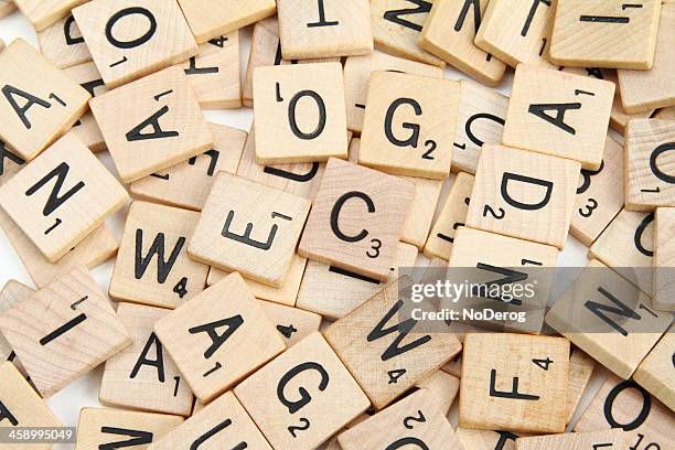 peças de letras do scrabble espalhadas por ordem aleatória - jogo de palavras imagens e fotografias de stock