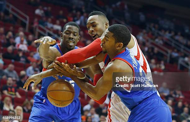 Dwight Howard of the Houston Rockets battles for the basketball against Henry Sims and Hollis Thompson of the Philadelphia 76ers during their game at...