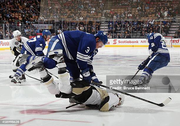 Dion Phaneuf of the Toronto Maple Leafs checks Pascal Dupuis of the Pittsburgh Penguins during the second period at the Air Canada Centre on November...