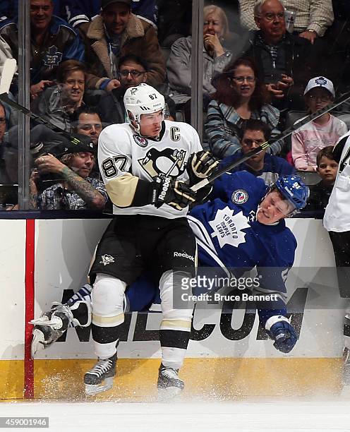 Sidney Crosby of the Pittsburgh Penguins slams Jake Gardiner of the Toronto Maple Leafs into the boards during the third period at the Air Canada...