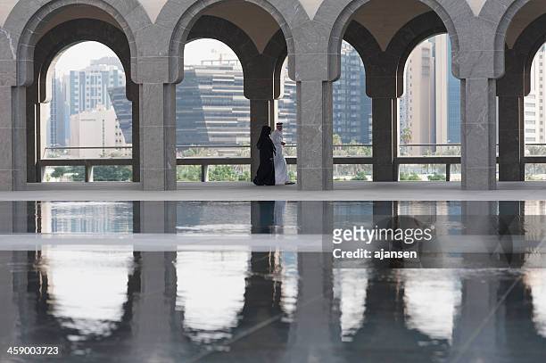 arabic man, woman at the museum of islamic art doha - doha museum stock pictures, royalty-free photos & images
