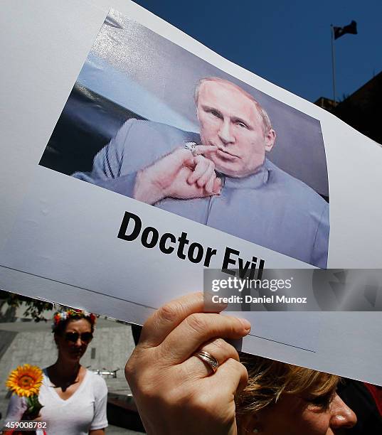 Woman holds banners against Russian President Vladimir Putin during a protest against G20 leaders on November 15, 2014 in Brisbane, Australia. World...