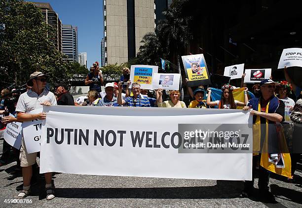 Woman holds banners against Russian President Vladimir Putin during a protest against G20 leaders on November 15, 2014 in Brisbane, Australia. World...