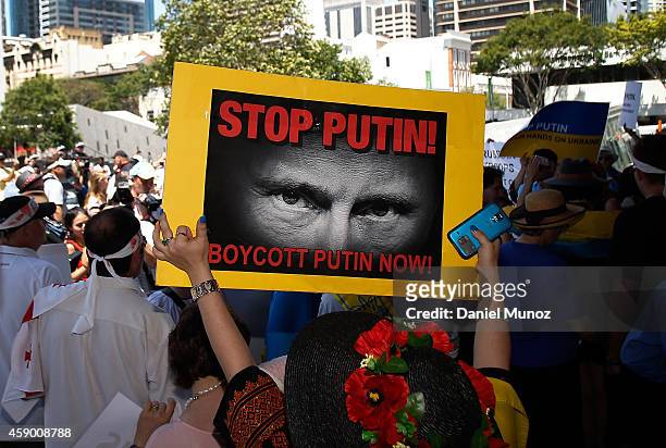 Woman holds banners against Russian President Vladimir Putin during a protest against G20 leaders on November 15, 2014 in Brisbane, Australia. World...