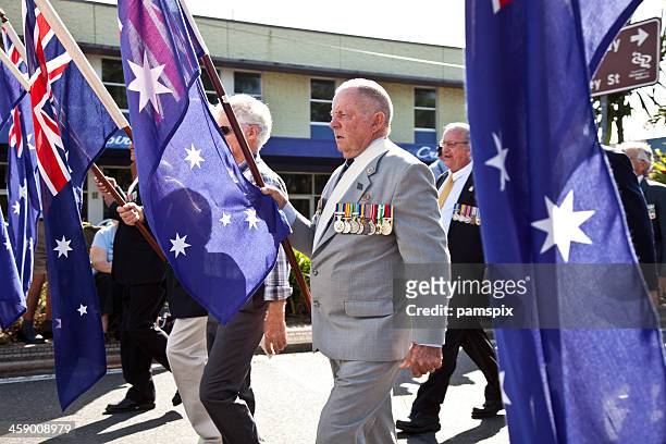 homens marchando australianos no dia de anzac com bandeiras - dia anzac - fotografias e filmes do acervo