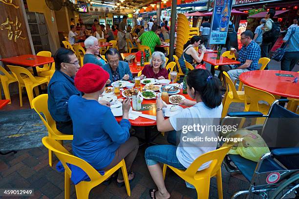 singapore family eating dinner in chinatown - singapore alley stock pictures, royalty-free photos & images