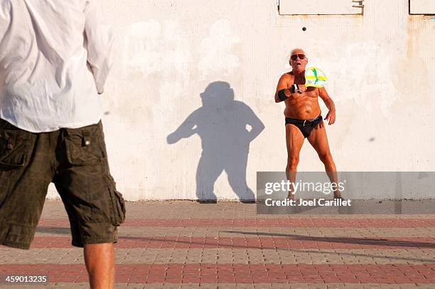 two men playing matkot in tel aviv, israel - old man in speedo stockfoto's en -beelden