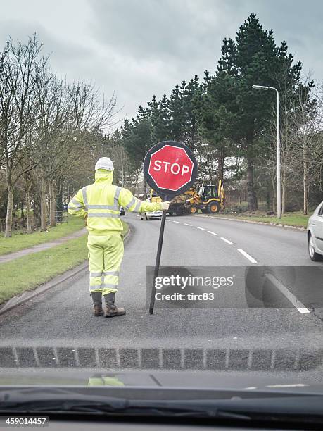 man with stop sign at rural roadworks - road construction safety stock pictures, royalty-free photos & images