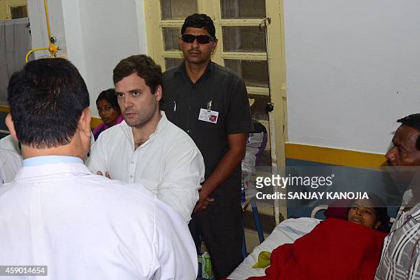 India's Congress party Vice President Rahul Gandhi speaks to doctors as he visits patients who suffered from complications that also killed 13 women...
