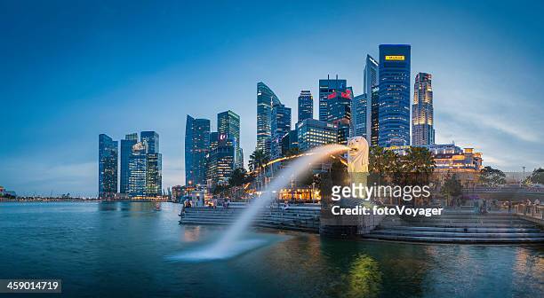 singapore merlion fountain cbd skyscrapers overlooking marina bay at dusk - singapore stock pictures, royalty-free photos & images