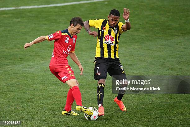 Isaias of Adelaide United competes for the ball with Kenny Cunningham of Wellington Phoenix during the round six A-League match between Adelaide...