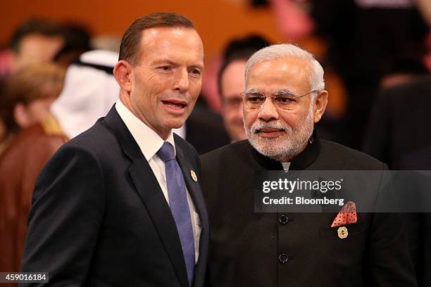 Tony Abbott, Australia's prime minister, left, speaks with Narendra Modi, India's prime minister, as they arrive for a plenary session at the Group...