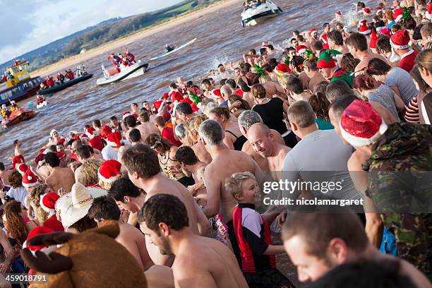 annual christmas day swim:  exmouth, devon, 2012 - nicolamargaret stock pictures, royalty-free photos & images