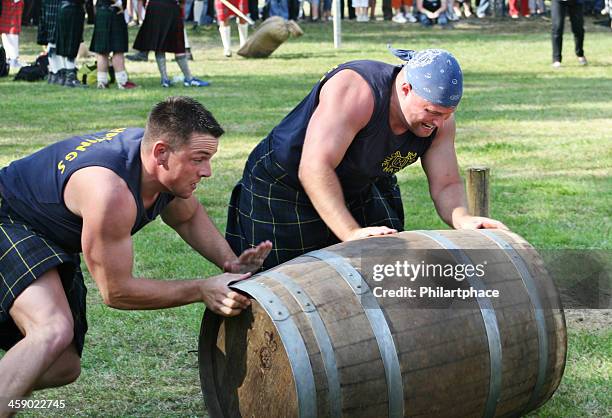 starke männer im highland games - rolling stock-fotos und bilder