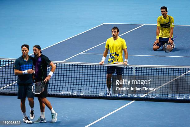 Marcelo Melo of Brazil and Ivan Dodig of Croatia look to the screen after Lukasz Kubot of Poland and Robert Lindstedt of Sweden challenged a point in...