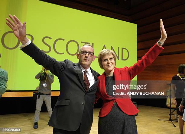 New leader of the Scottish National Party Nicola Sturgeon and new deputy SNP leader Stewart Hosie wave to the audience after she delivers her first...