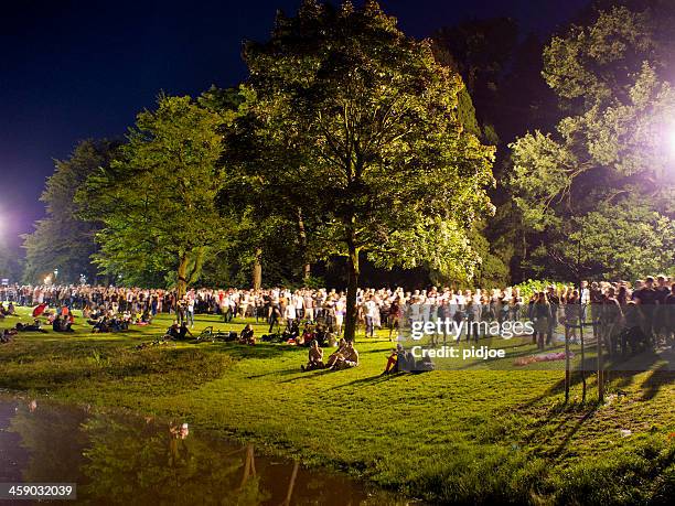 people walking through park after concert at night - nijmegen stock pictures, royalty-free photos & images