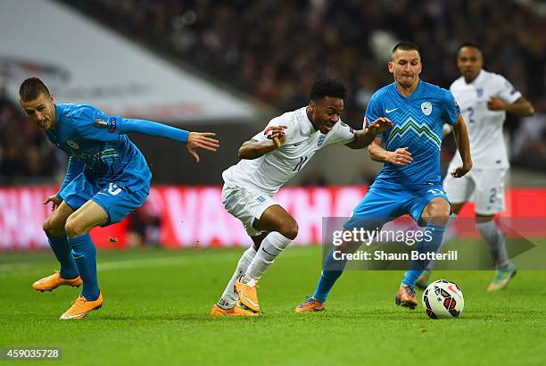 Raheem Sterling of England goes between Andraz Struna (L0 and Andraz Kirm of Slovenia during the EURO 2016 Qualifier Group E match between England...