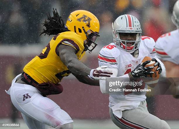 Barrett of the Ohio State Buckeyes scrambles under pressure from De'Vondre Campbell of the Minnesota Golden Gophers during the fourth quarter of the...