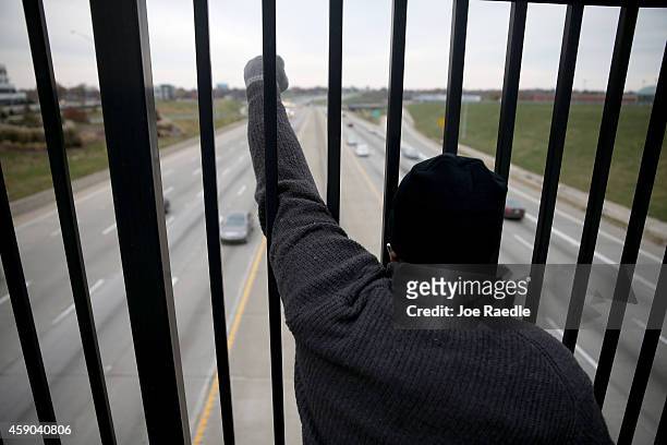 Demonstrators yell "Hands Up, Don't Shoot" alongside a highway overpass to voice their opinions as the area awaits a grand jury decision on November...