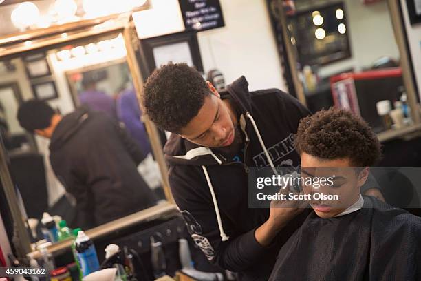 Barber Branden Turner cuts Malik Harry's hair at the Prime Time Barber and Beauty shop on West Florissant Street November 15, 2014 in Ferguson,...