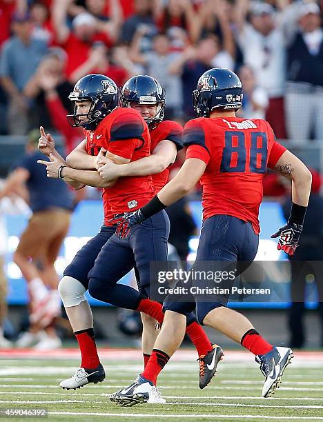 Place kicker Casey Skowron of the Arizona Wildcats celebrates with Drew Riggleman and Trevor Wood after Skowron kicked the game winning 47 yard field...