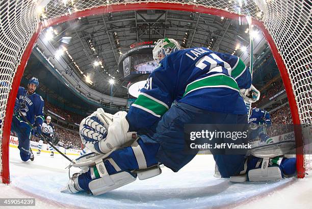 Jason Garrison eyes the loose puck after Eddie Lack of the Vancouver Canucks make a save against the Winnipeg Jets during their NHL game at Rogers...