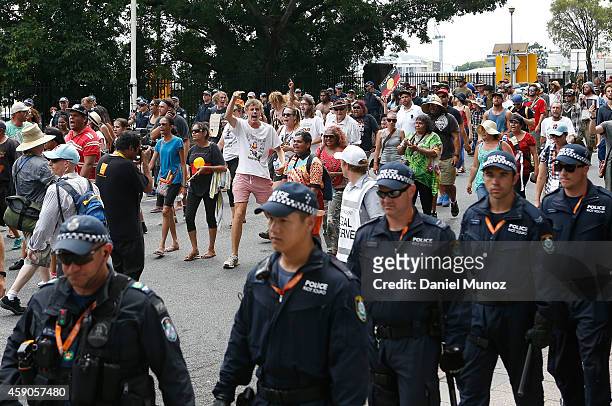 People attend a protests for Australian Aboriginal rights and against the G20 leaders as police walks next to them on November 16, 2014 in Brisbane,...