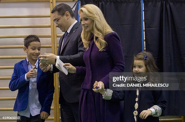 Romanian Prime Minister and presidential candidate Victor Ponta speaks with his wife Daciana Sarbu and their children before voting at a polling...