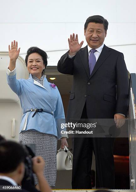 In this handout photo provided by the G20 Australia, China's President Xi Jinping and First Lady Peng Liyuan wave before departing Brisbane Airport...