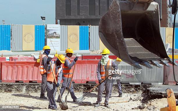 Workers are seen at a construction site in Doha, on November 16, 2014. Qatar, host of the 2022 football World Cup, pledged to introduce new...