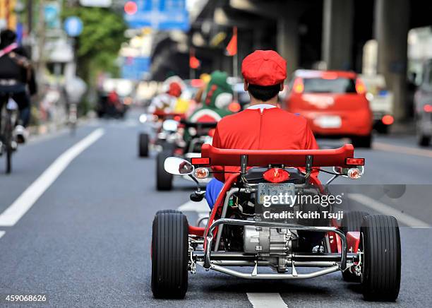 Participants drive around Tokyo in Mario Kart characters for the Real Mario Kart in Tokyo on November 16, 2014 in Tokyo, Japan. The organizer calls...