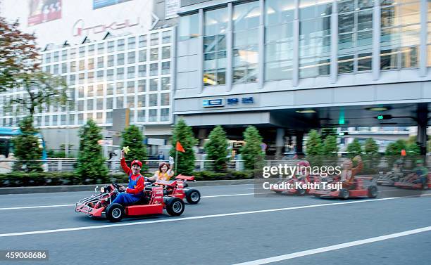 Participants drive around Tokyo in Mario Kart characters for the Real Mario Kart event in Tokyo on November 16, 2014 in Tokyo, Japan. The organizer...