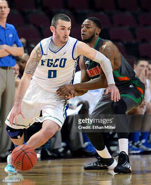 Brett Comer of the Florida Gulf Coast Eagles drives against Jomari Bradshaw of the Florida A&M Rattlers during the 2013 Continental Tire Las Vegas...