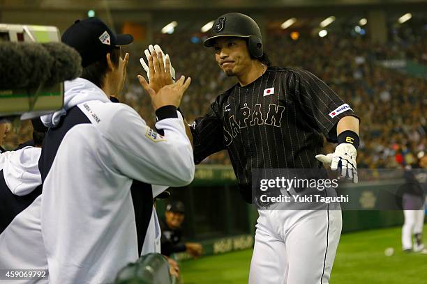 Nobuhiro Matsuda of the Samurai Japan is greeted in the dugout after scoring a run in the second inning during the game against the MLB All-Stars at...